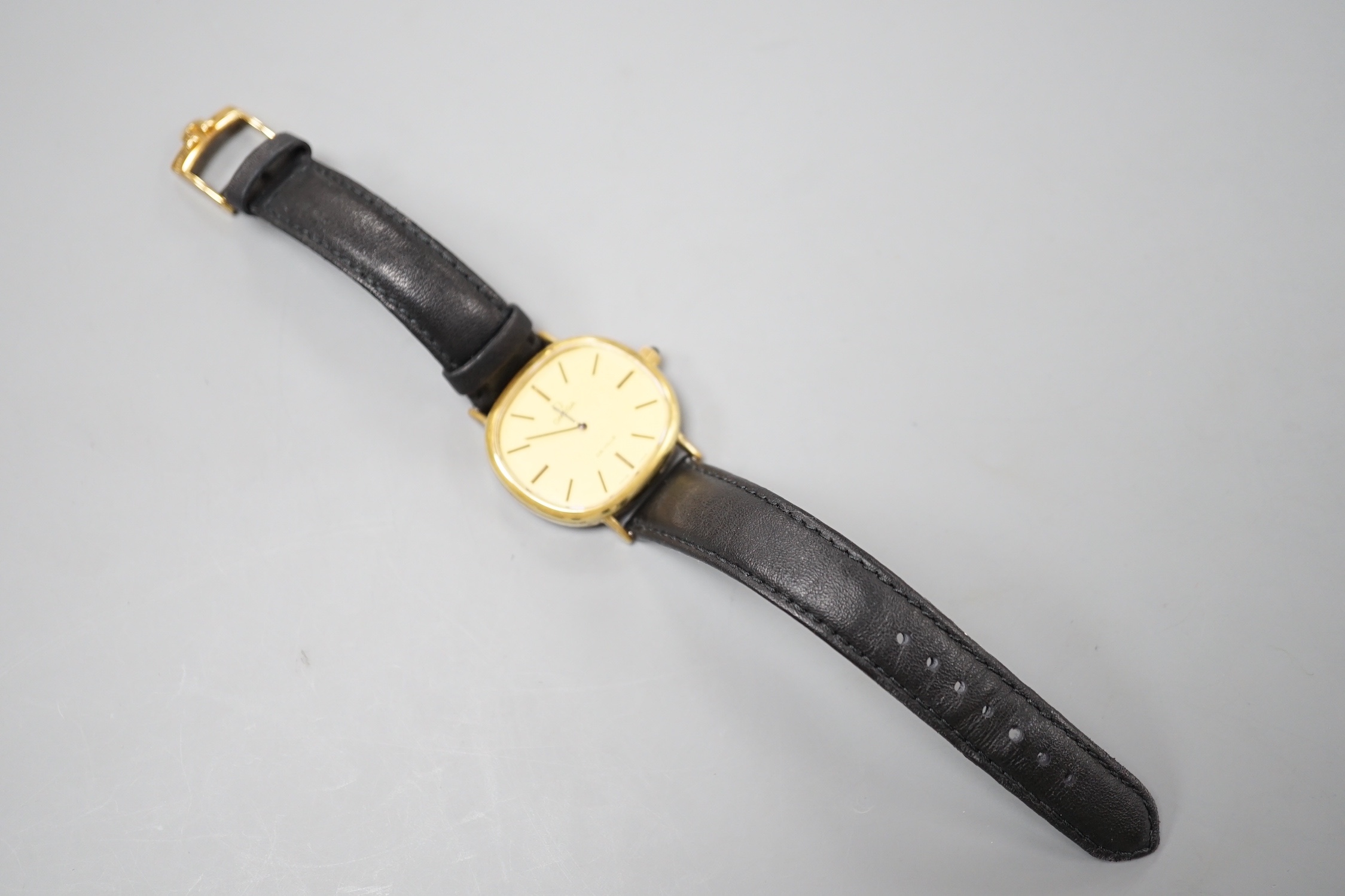 A gentleman's gold plated Omega de Ville manual wind wrist watch, on a black leather strap, with Omega buckle, case diameter 33mm, no box or papers.